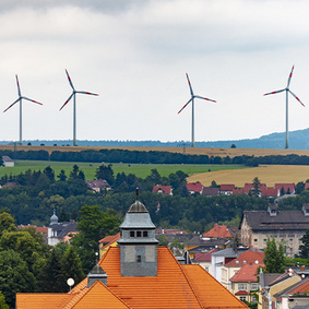 Kommune mit Windrädern im Hintergrund
