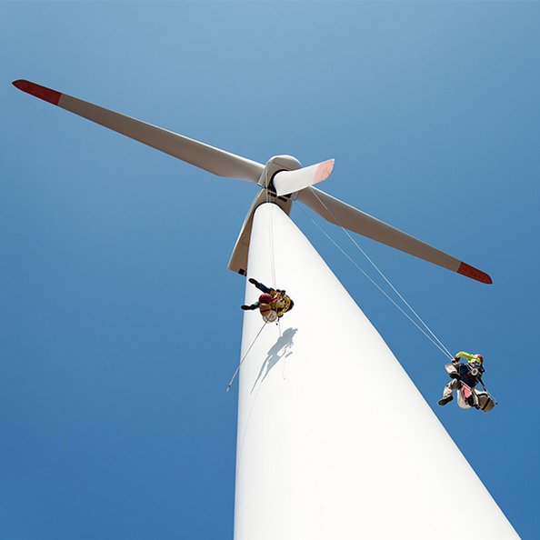 Betriebsführung von Windenergieanlagen - Männer seilen sich an Windrad ab
