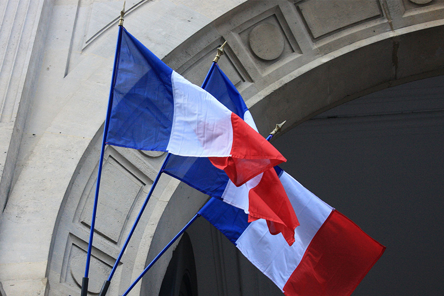 Französische Flaggen vor historischem Gebäude